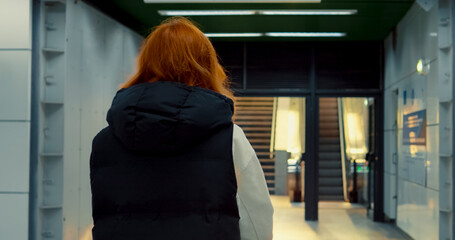 Young mother with stroller exits subway station and navigates city streets