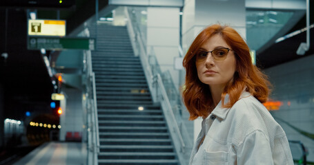 Mother pushes stroller on urban subway platform during busy travel time