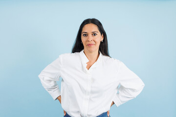 portrait of adult mexican woman smiling on blue background in Mexico Latin America, or Latina middle aged brunette female 
