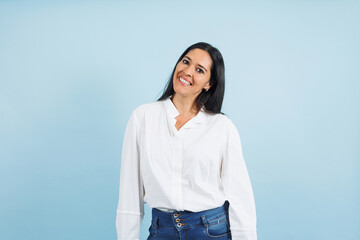 portrait of adult mexican woman smiling on blue background in Mexico Latin America, or Latina middle aged brunette female 