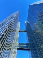 Obraz premium Modern Glass Skyscrapers with Skybridges Against Clear Blue Sky