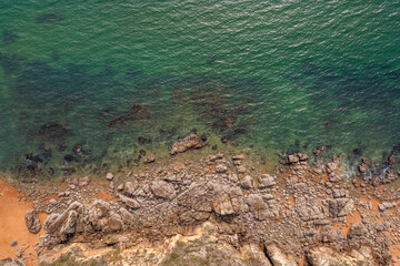 Beautiful ocean landscape from a drone. Rocks, turquoise water, and beach. Vacation travel.
