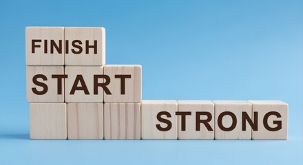 Conceptual Image of Blocks Spelling Start, Finish and Strong on a Blue Background, Symbolizing Success and Positive Thinking