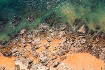 Beautiful ocean landscape from a drone. Rocks, turquoise water, and beach. Vacation travel.