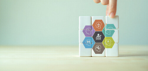 Colorful business strategy blocks with icons on a table being stacked by a hand