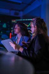 Dedicated business team working late on corporate project. Professional women analyzing digital...