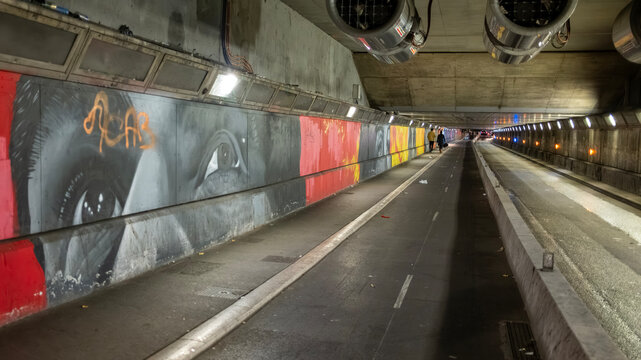 Nice, France - December 25, 2025: Pedestrian and vehicle tunnel with graffiti murals and street art along the wall in Nice, on the French Riviera. The underground passage features painted artwork and 