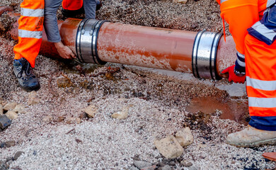 Fast response repair team builders replacing damaged foul sewer drainage pipe