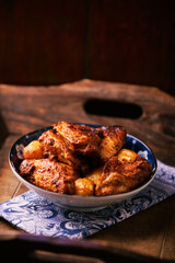 Fried chicken wings with potatoes on a rustic background
