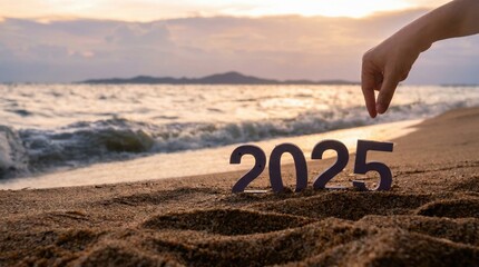Hand placing number 5 in 2025 on sandy beach at sunset,concept for new year,goals,planning,future and hope with calm seascape
