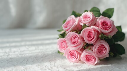 Soft pink roses bouquet arranged on a delicate lace surface with soft light