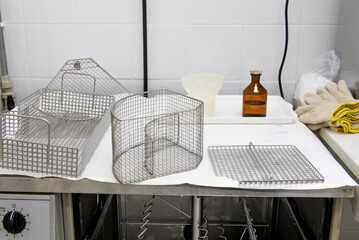 Laboratory dishwasher with baskets and laboratory bottle on top.