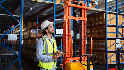 Professional warehouse workers using digital tablet with forklift and pallets. Logistics team management, inventory control, and industrial supply chain concept.