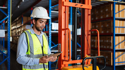 Professional warehouse workers using digital tablet with forklift and pallets. Logistics team management, inventory control, and industrial supply chain concept.