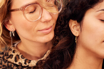 Close up portrait of two women in a calm moment, showcasing fashion, jewelry  and diverse style