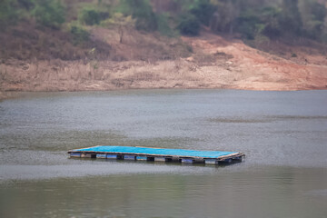 A simple floating dock made from bamboo and plastic buckets.