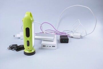Electronic chargers and cables, power banks and flashlight on table 