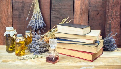 Healing herbal remedies, ancient books, bouquets of mystical herbal potions and candles on wooden background