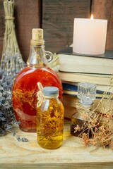 Healing herbal remedies, ancient books, bouquets of mystical herbal potions and candles on wooden background