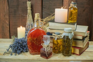 Healing herbal remedies, ancient books, bouquets of mystical herbal potions and candles on wooden background