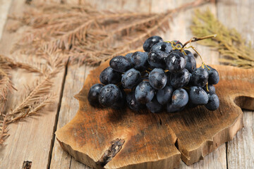 Fresh Black Grapes on Wooden Table With Rustic Details in Natural Setting