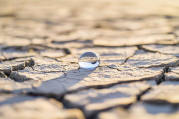 Water scarcity and drought concept with single water drop on cracked dry soil climate change global water crisis