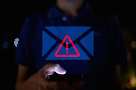 Man receiving alert on phone about suspicious email message at night - Powered by Adobe