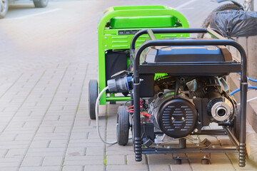 Diesel power generator. Business uses two mobile generators. Outdoor power supply generator placed on street sidewalk. Energy independence.
