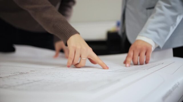 Architects reviewing architectural plans on work table