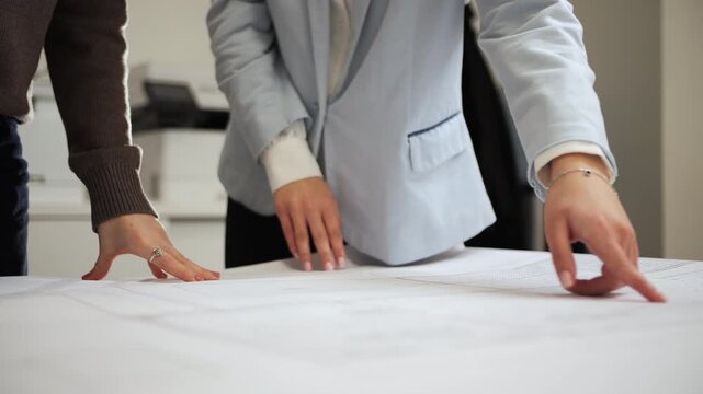 Architects discussing project plans over architectural drawings