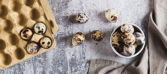 Fresh unpeeled quail eggs in a bowl and on the table top view web banner