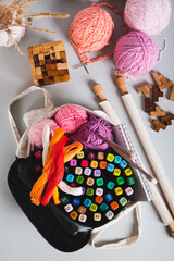 Analog bag of yarn, markers, a notebook, knitting needles, and puzzles top and vertical view