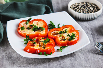 Fried red bell pepper rings with omelette and herbs on a plate on the table
