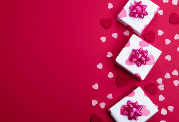 Beautiful and romantic valentines background with present and hearts in red for valentines day or anniversary holiday celebration with copy space