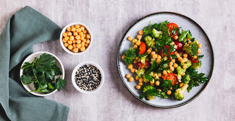 Mix of chickpeas, tomatoes, broccoli and parsley on a plate on the table top view web banner