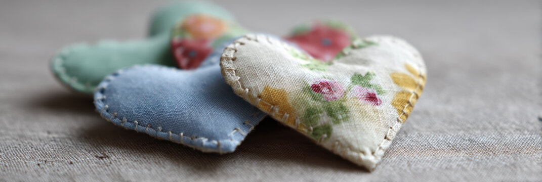 Handmade fabric heart stitched textile heart patchwork heart soft pastel color floral pattern linen background cozy craft vibe rustic home decor romantic gift idea upcycled material