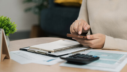 Fototapeta premium The concept of tax return preparation and financial management. Businessman calculates taxes using calculator and laptop. finance, Income tax, tax documents, and savings, File taxes online.