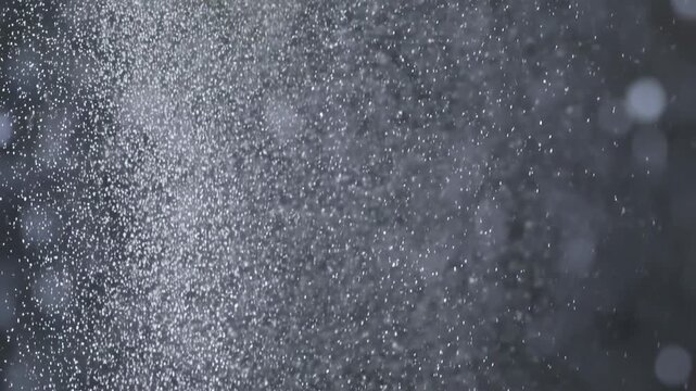 Slow motion falling water particles creating gentle misty atmosphere