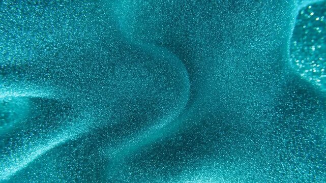 Dynamic blue glitter waves creating mesmerizing abstract oceanic movement