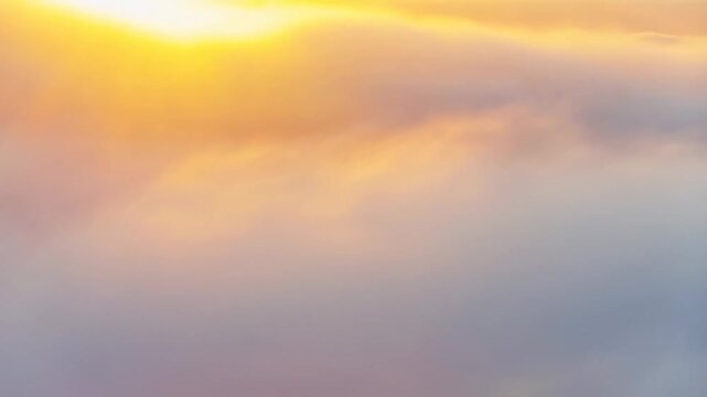 Golden sunrise illuminating rolling clouds and skyward horizon in serene morning scene