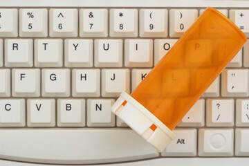 Prescription pill bottle on keyboard healthcare concept