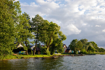 Lakeside vacation houses and docks at sunset on Jezioro Kłodno lake, Kashubia, Poland