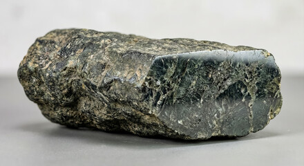 A collectible geological specimen of close up view of fibrous riebeckite variety known as crocidolite with silky luster and dense mineral structure on a polished cross-section.