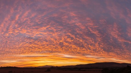 Fototapeta premium panoramic. A vibrant sunset over an open field, blending warm orange and purple hues across a panoramic sky. inspiring travel planning. 