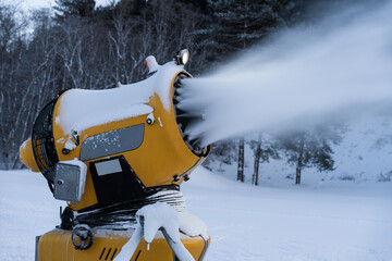 Snow cannon. A snow making machine on the ski slope to prepare the ski resort for the next day. The winter sports industry.