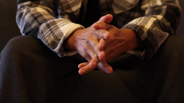 Nervous man fidgeting his hands together