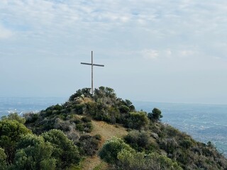 Large cross on the mountain near Holy Monastery of Stavrovouni, Cyprus, standing against the sky as a symbol of faith, Orthodox tradition, pilgrimage, and dramatic rocky landscape