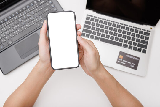 Hands using smartphone mockup on office desk. Blank screen mobile phone for graphic display montage - Powered by Adobe