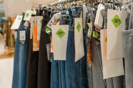 Paris, France - 01 10 2026: Clothes hanging on hangers with sale tags in a store during the sales