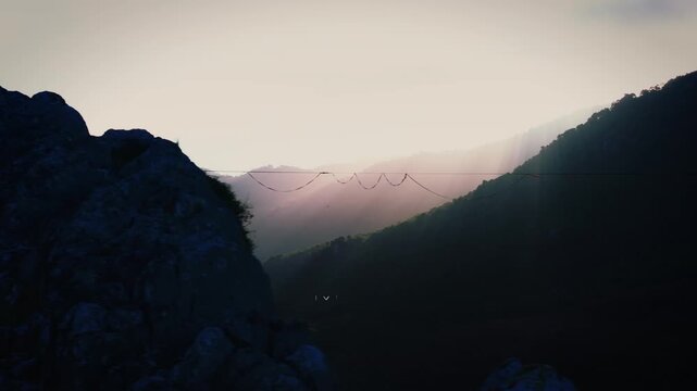 A lone figure walks the slackline, kissed by the soft glow of sunrise